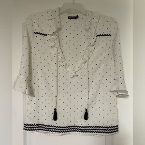 Polka dot black and white shirt with bell sleeves.